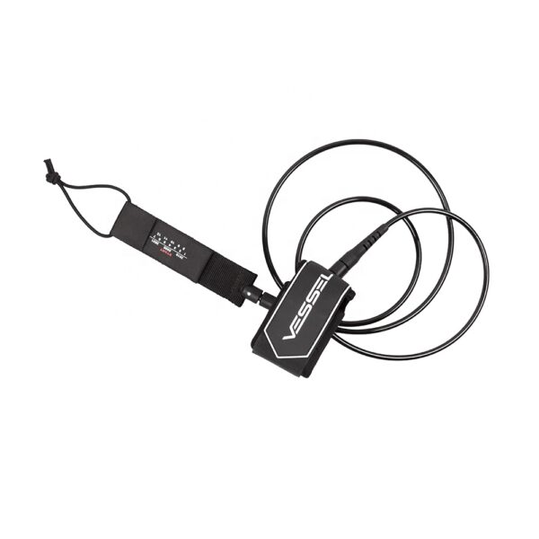 This image provides a top - down perspective of the black Vessel ankle leash. It clearly shows the coiled design and the small tag at the end of the leash. The brand name "VESSEL" is visible on the strap.