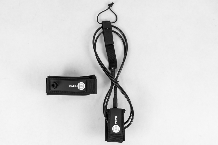 Black surfboard leash with detachable cuff and PVC logo shown flat