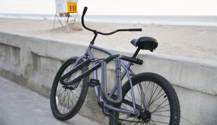 Surfboard bike rack mounted on cruiser bicycle by the beach wall