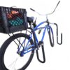 Blue cruiser bike equipped with black surfboard rack and rear cargo box near the beach