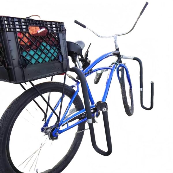 Blue cruiser bike equipped with black surfboard rack and rear cargo box near the beach