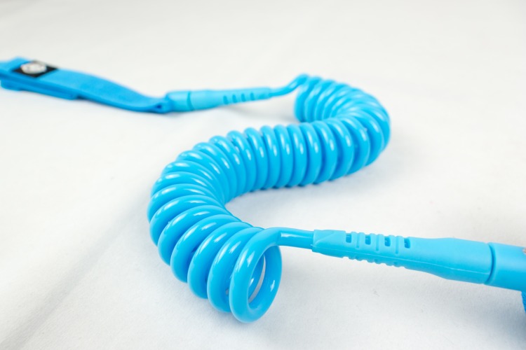 Close-up of bright blue coiled TPU cord on premium SUP leash