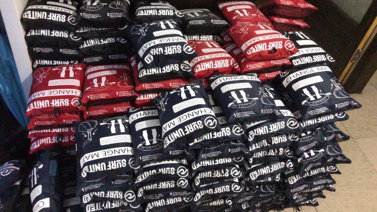 Bulk-packed surf changing mats with SURF UNITED branding in black and red