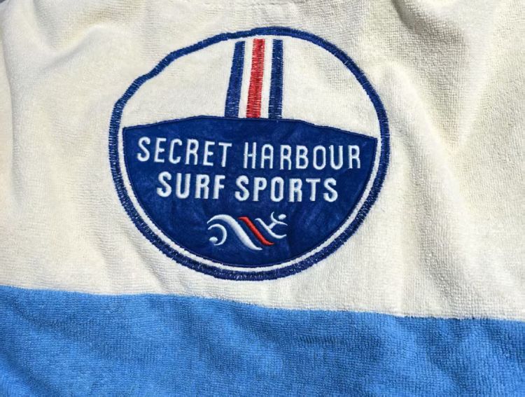 Secret Harbour Surf Sports logo embroidery on blue and white poncho