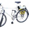 White mountain bike fitted with front and rear surfboard rack arms, parked on grass