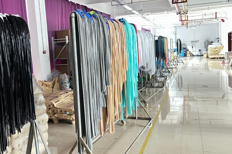 Multiple colored TPU cords for surf leashes hanging in production workshop