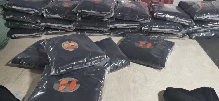 Bulk packed surf ponchos in transparent plastic bags with logo embroidery