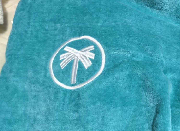 Turquoise surf poncho with white palm tree logo embroidery on chest