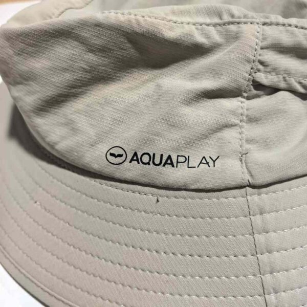 _cuva This image shows the brand label on the surf fishing hat. The label reads "AQUAPLAY" and is located on the side of the hat, which is light beige with a wide brim.