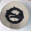 _cuva The image shows the inside of a surf fishing hat. The hat has a light beige color with a wide brim. The interior features a black adjustable strap with a plastic buckle, and a sweatband for comfort.