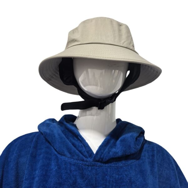 Surf Fishing Hat on a Mannequin The image shows the surf fishing hat worn by a mannequin. The hat is light beige with a wide brim, and it has a black adjustable strap under the chin. The mannequin is dressed in a blue hoodie.