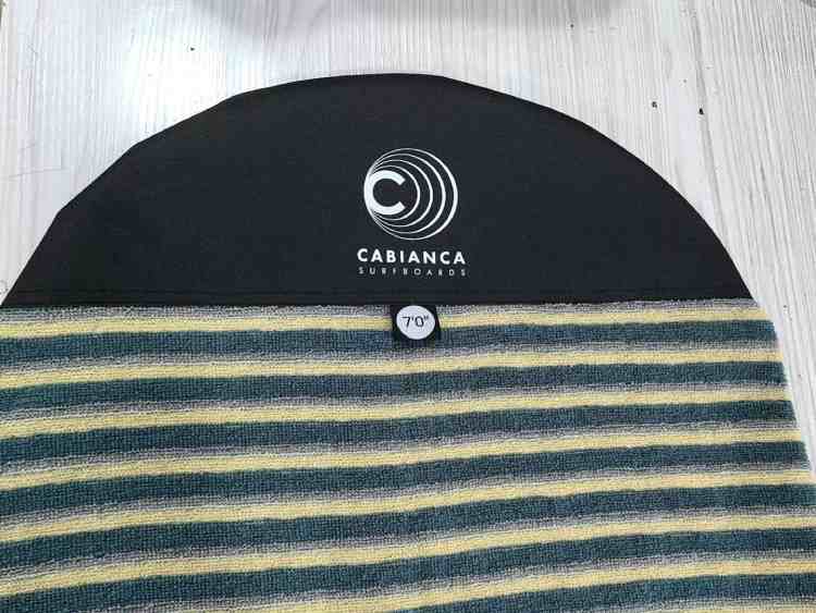 The image features a close - up of a logo surfboard cover with the "el nino" label and a size indication of "7'0"".