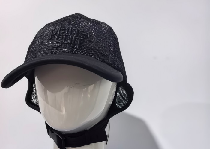 The image shows a black mesh cap worn by a mannequin. The cap has a mesh design with a solid black brim, and the brand name "Planet Surf" is embroidered on the front. The cap also features an adjustable strap under the chin.
